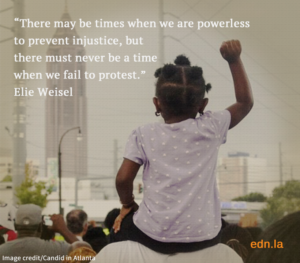 Child on shoulders raising fist with quote